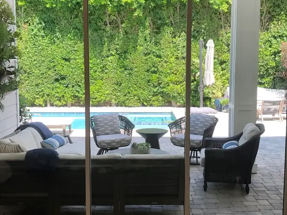 Finished sliding glass doors opening onto a pool patio, filmed for security and heat.