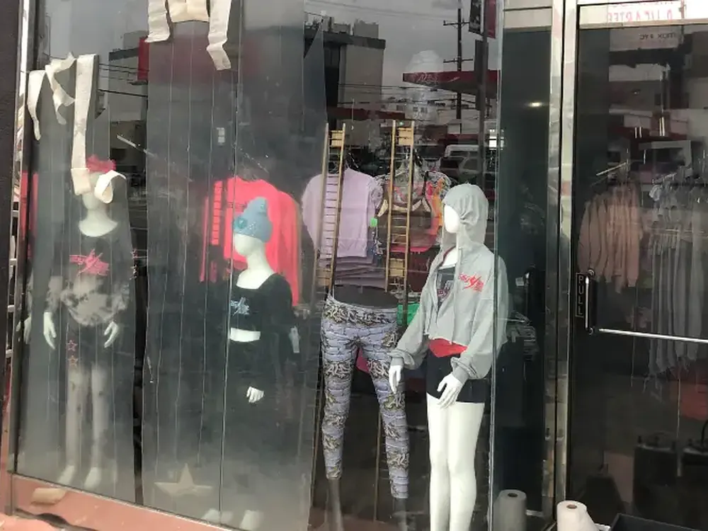 A boutique window clouded with scratch damage before anti-graffiti film went on.